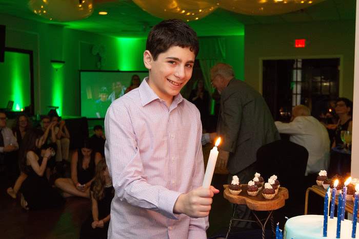 boy lighting candles at mitzvah in Marietta, GA